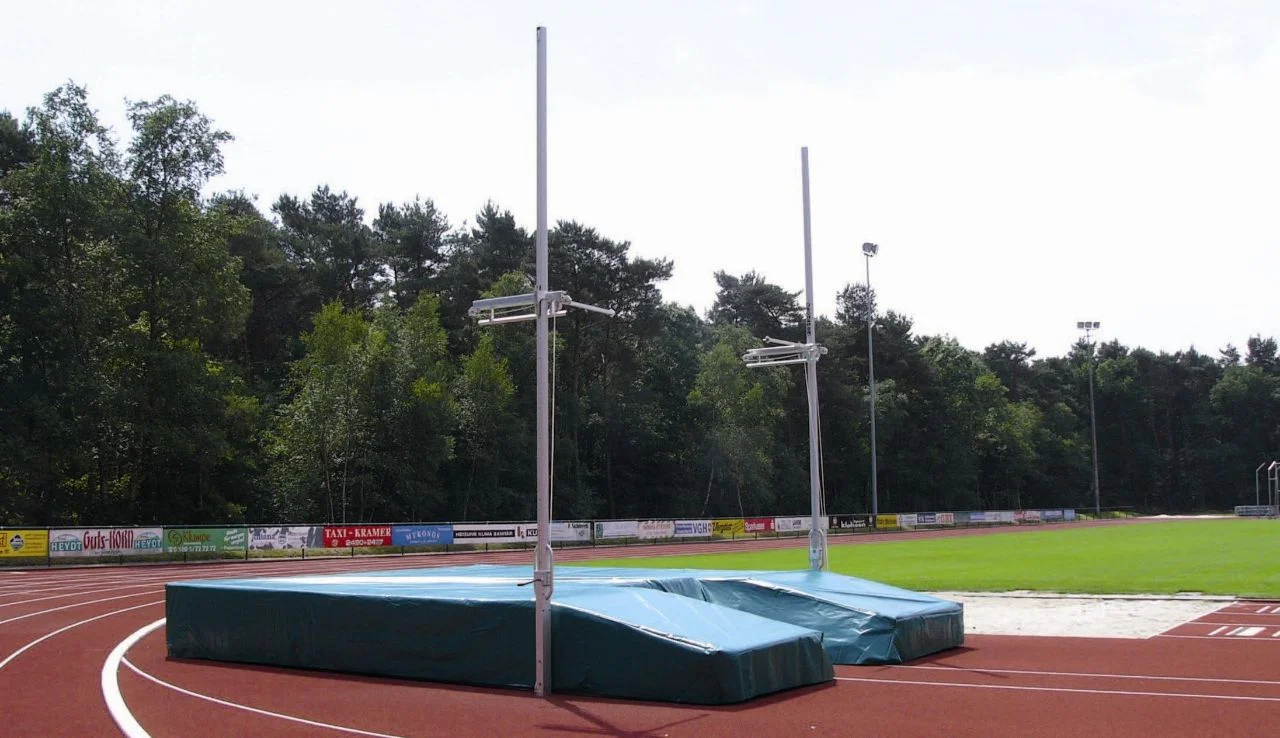Standard pole vault uprights in ground sleeves
