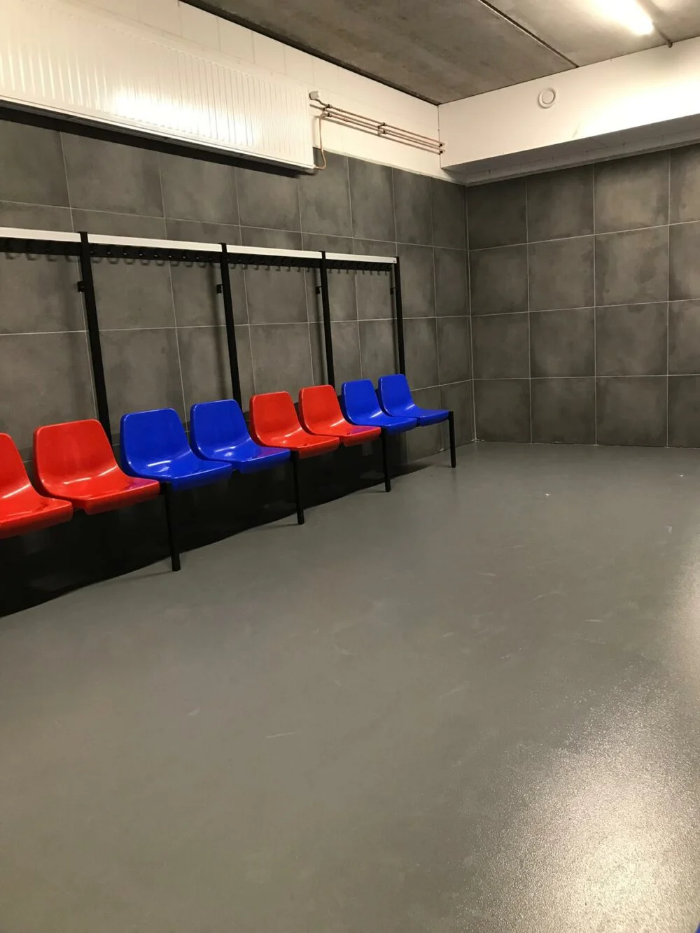 Wandbanken met blauwe en rode CR4 stoelen bij KFC