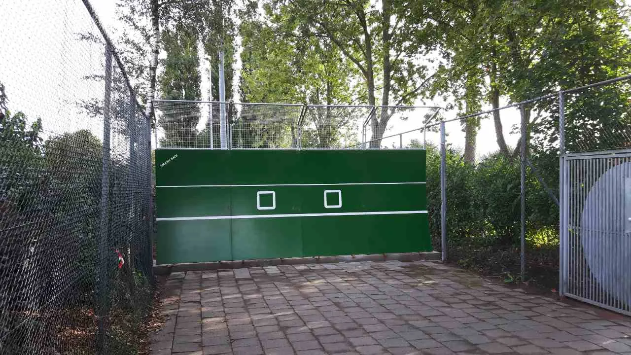 Tennismuur van polymeerbeton met balvanger bij TC Zwaanshoek